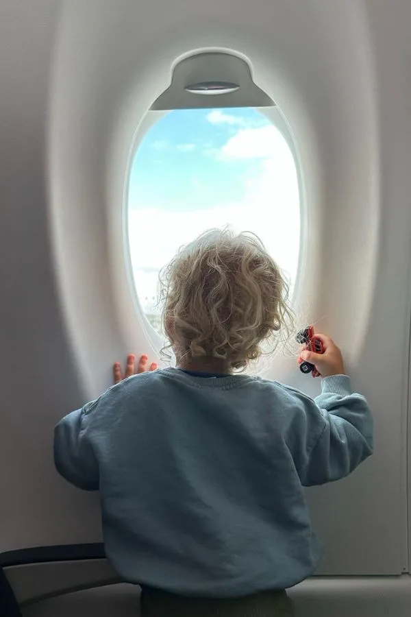 Little boy looking out of an airplane window to the clouds - Barrett and the Boys